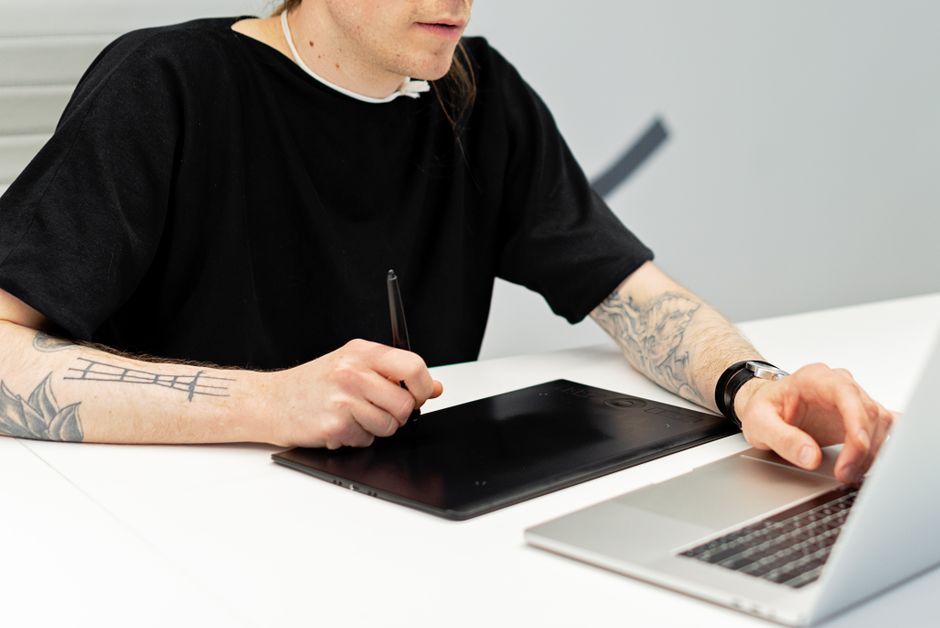 A digital artist using a graphic tablet to edit a detailed landscape, with an overlay showing inpainting and outpainting boundaries being adjusted by an AI tool.